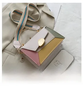 Dettaglio borsa a tracolla in pelle color-block con cinturino arcobaleno e manico oro