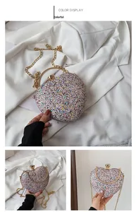 Detailed view of a multi-color heart-shaped evening clutch with sparkling sequins and gold handle