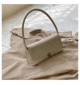 Detail view of oatmeal-colored faux suede and leather shoulder bag with gold metal ring handle