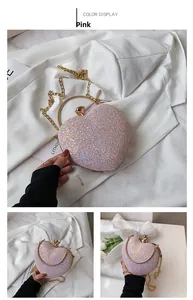 Detailed close-up of pink heart-shaped evening bag with glitter finish and gold ring handle