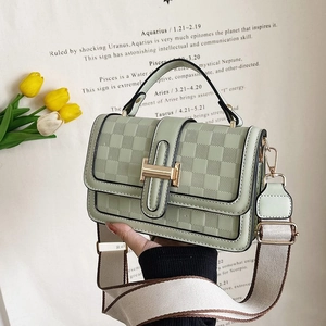 Detail of mint green crossbody bag with checkered texture and golden H buckle closure