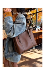 Dettaglio della borsa tote in pelle marrone con cuciture a contrasto e fibbia regolabile