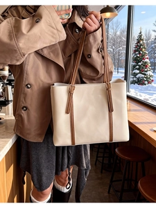 Dettaglio della borsa tote minimalista in tessuto crema con finiture in pelle marrone