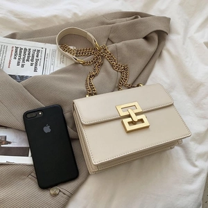 Chic beige crossbody flap bag with large gold square lock and elegant chain strap