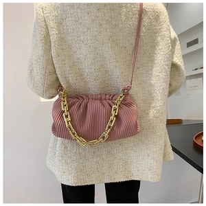 Detailed view of pink pleated cloud bag with chunky gold chain and leather strap