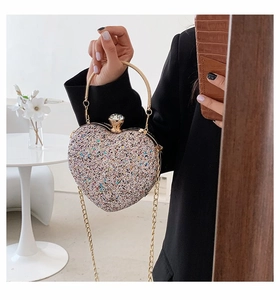 Detail of heart-shaped evening bag with colorful sequins and crystal gem lock