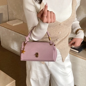 Elegant mauve leather handbag for women featuring gold star pendant and knot handle detail