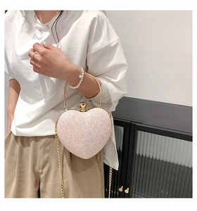 Macro shot of heart-shaped glitter evening bag with gold ring handle and gem clasp