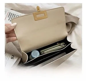 Top view of cream crossbody bag open interior with multiple compartments and gold clasp