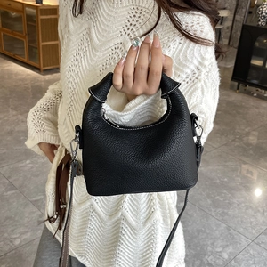 Minimalist black lychee leather handbag with pleated handle and long shoulder strap