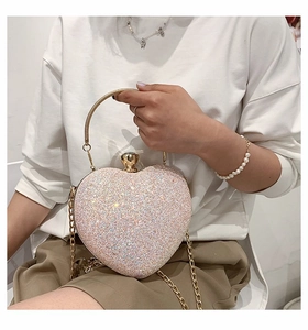 Detail of pink sequin heart clutch bag with gold round handle and chain strap