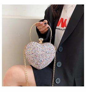 Detail of heart-shaped sequin clutch bag with metal ring handle and crystal clasp