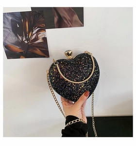 Detail of heart-shaped evening bag with iridescent sequins and gold metal chain