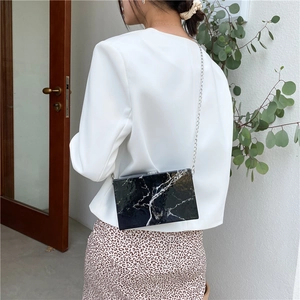 Fashionable marble pattern box bag with silver metal chain strap shown on model