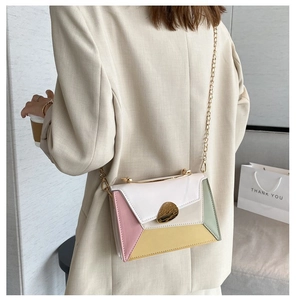 Vista posteriore della modella con borsa a catena color-block nei toni pastello bianco e rosa