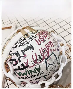 Détail du sac rond graffiti avec double fermeture éclair et grosse chaîne blanche