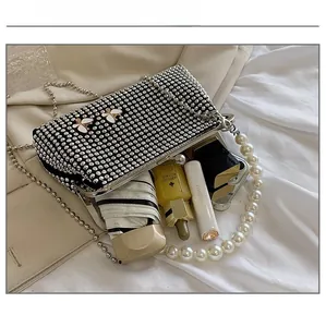 Macro view of black evening bag with crystal butterfly and pearl handle showing large capacity