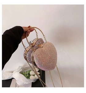 Detail view of heart-shaped sequin evening bags with rhinestone clasp and metal ring handle