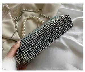 Detail view of rhinestone cylinder evening bag with large pearl handle and silver chain