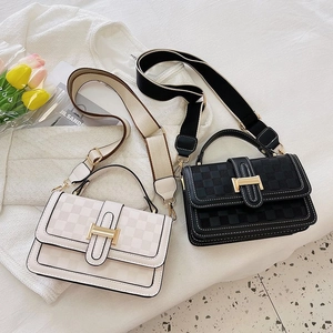 Close-up of quilted pattern and gold buckles on white and black crossbody flap bags