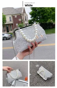 Detail of white rhinestone evening bag featuring pearl handle and silver metal butterfly accents