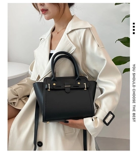 Chic black handbag with gold buckle detail styled with a beige trench coat for women
