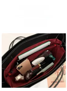 High capacity black tote bag interior showing compartments and various daily essentials
