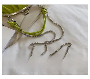 Détail du sac plissé vert citron avec bandoulière en chaîne argentée et boucle en métal