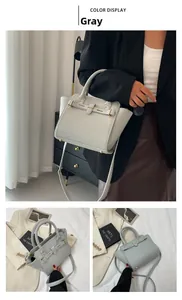 Detail of grey lychee-grain handbag featuring gold metal hardware and adjustable strap