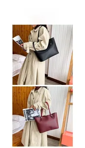 Detail of minimalist leather tote bag showing crossbody style in black and burgundy colors