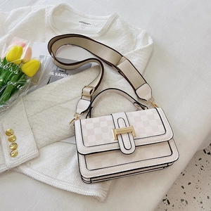 Detail of cream crossbody bag featuring checkerboard texture and golden H-shaped metal buckle