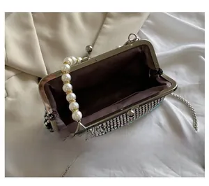 Detail view of the rhinestone evening clutch interior with metal clasp and pearl handle
