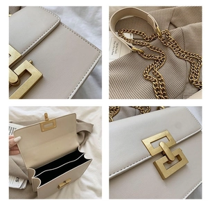 Detail view of beige crossbody bag with gold geometric clasp and chain strap