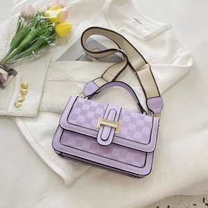 Detail of purple square bag with checkerboard pattern, golden H-clasp and canvas strap