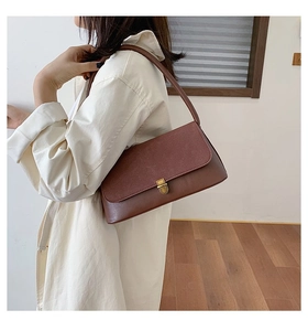 Detail of dark brown retro shoulder bag featuring vintage gold clasp and leather texture