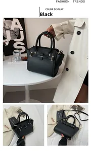 Detail of black lychee grain leather handbag with gold lock and sleek shoulder strap