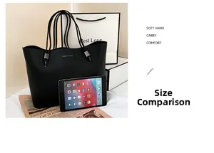 Detail view of large black tote bag showing size scale next to an iPad device
