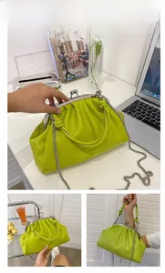 Détail du sac à main vert plissé avec fermoir métallique et bandoulière en chaîne