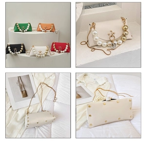 Detailed view of fashion handbag featuring pearl handle and metallic protective feet