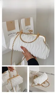 Close-up of white pleated cloud bag with gold metal handle and V-quilted texture