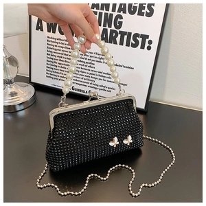 Detail of black rhinestone evening bag with pearl butterflies and beaded handle