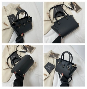 Detail view of black lychee leather bag with gold hardware and protective metal feet