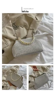 Close-up of white shell evening bag featuring large pearl handle and silver studs