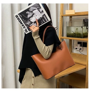 Brown leather tote bag shown on shoulder for daily commute with large capacity