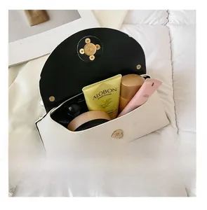 Detail view of the pearl handbag interior showing capacity for cosmetics and a gold clasp