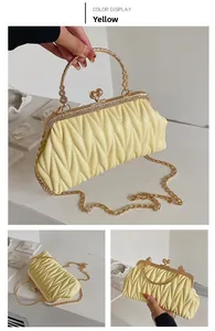 Close-up of yellow pleated cloud bag with V-shaped texture and gold metal handle
