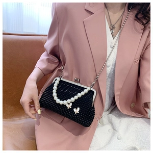 Detail of black rhinestone evening bag featuring pearl handle and butterfly charms