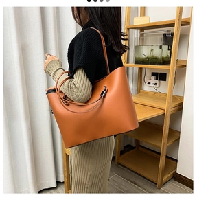 Brown leather tote bag shown on a model highlighting its large capacity and stylish design