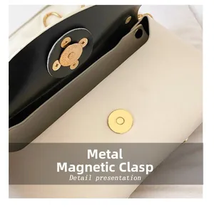 Detail presentation of golden magnetic snap closure on ivory leather handbag