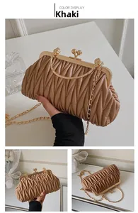 Detail of khaki pleated leather clutch with gold metal handle and ball clasp closure